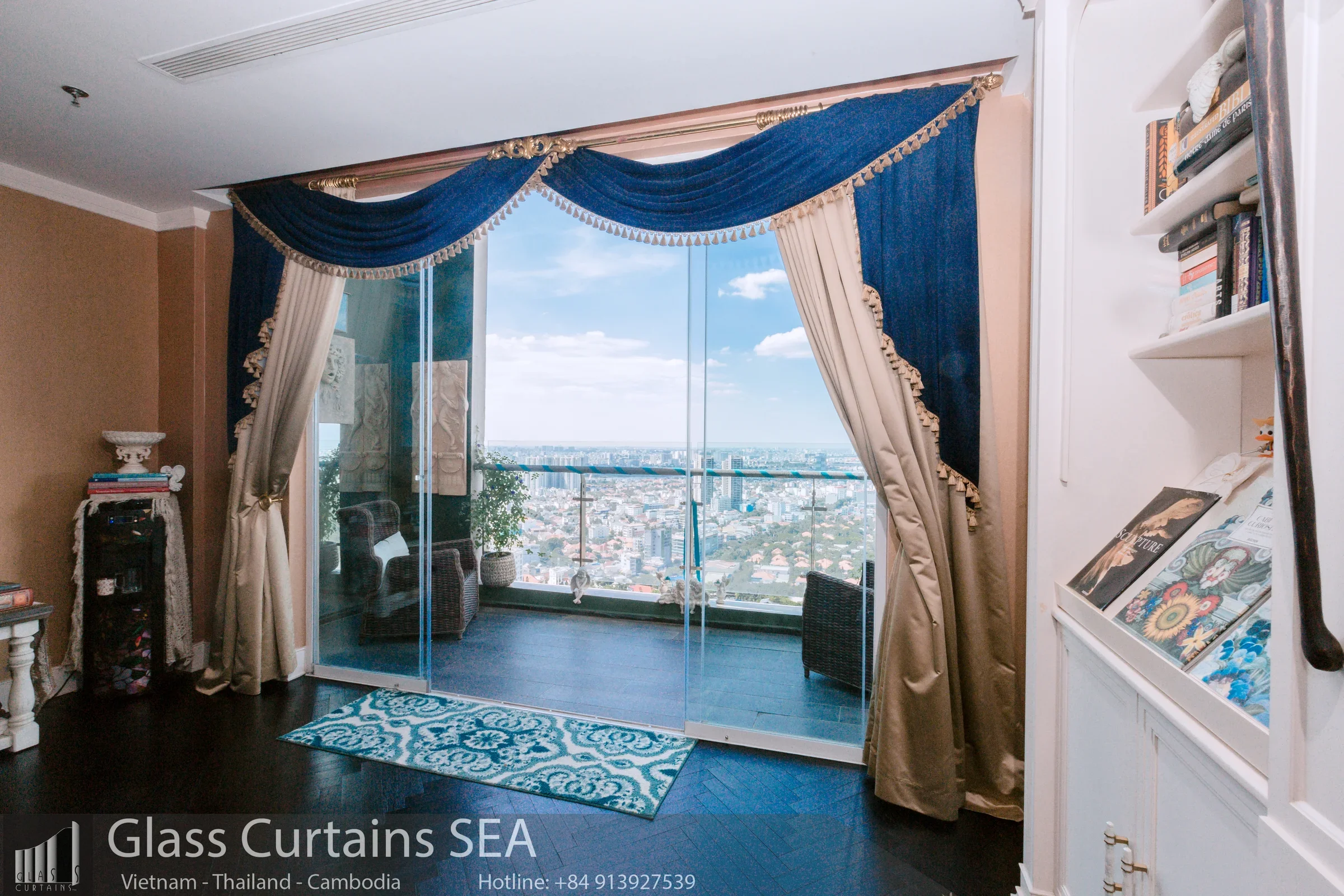 Ban công penthouse với cửa kính lùa lớn, tầm nhìn thành phố, rèm cửa sang trọng và nội thất tinh tế