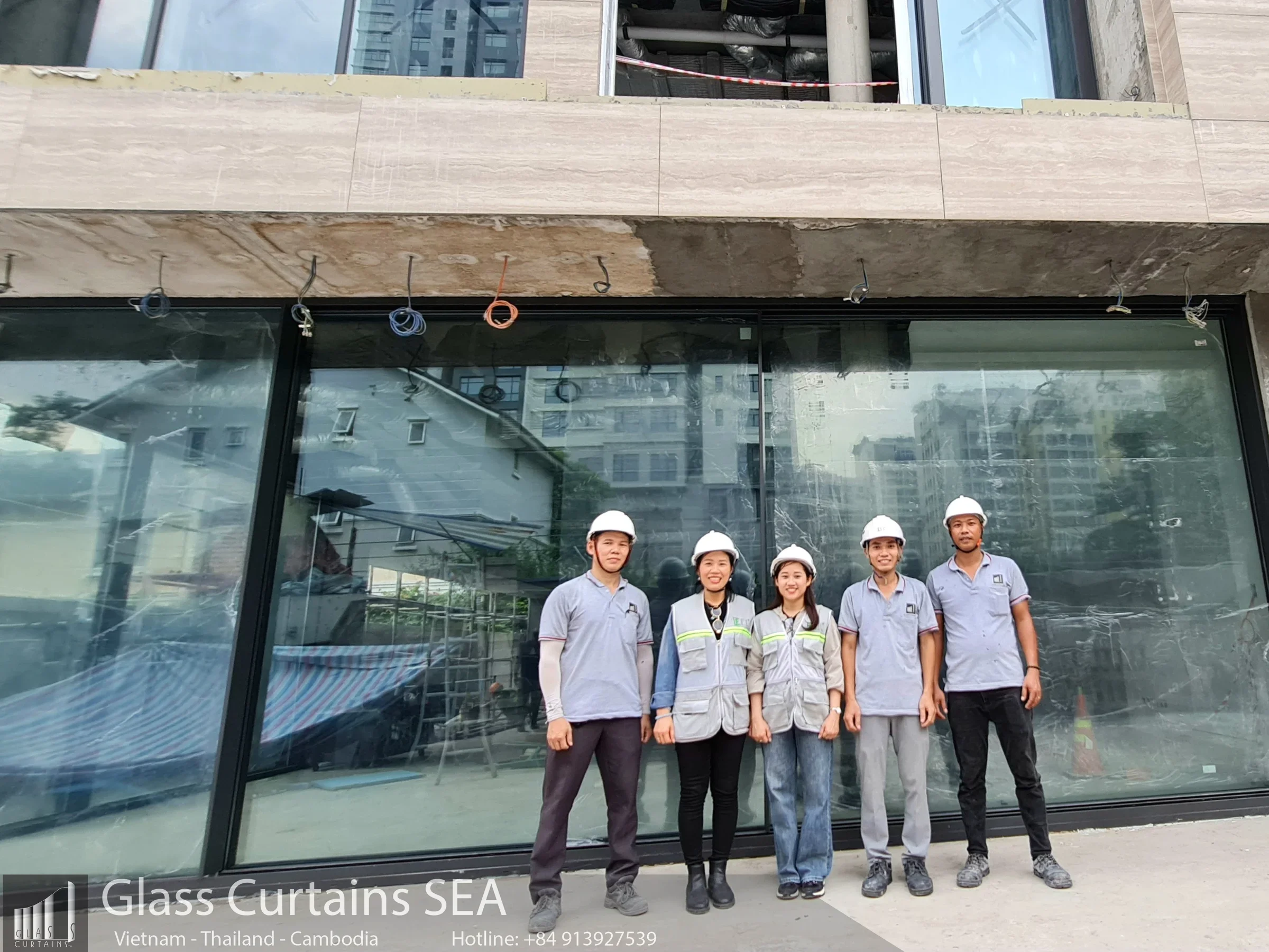 Năm kỹ thuật viên hoàn thành lắp đặt cửa nhôm kính hộp tại công trình xây dựng